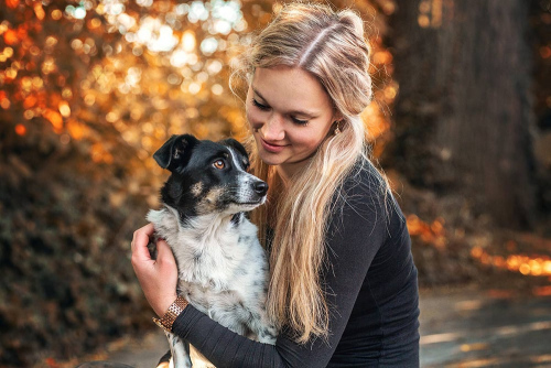 blondes Mädchen hält ihren Jack Russel Terrier im Arm