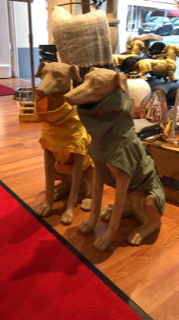 zwei Windhundfiguren mit Regenmänteln im Laden