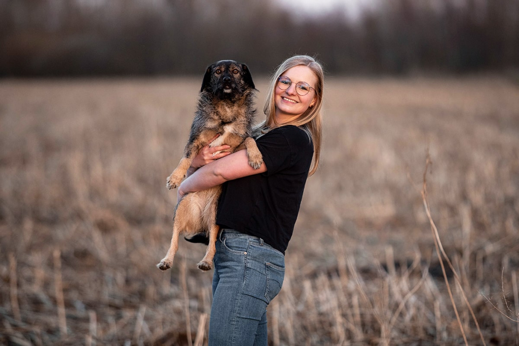 Hundefotografin Julia Hartmann mit ihrer eigenen Hündin Nelly auf einem Feld in Beelen